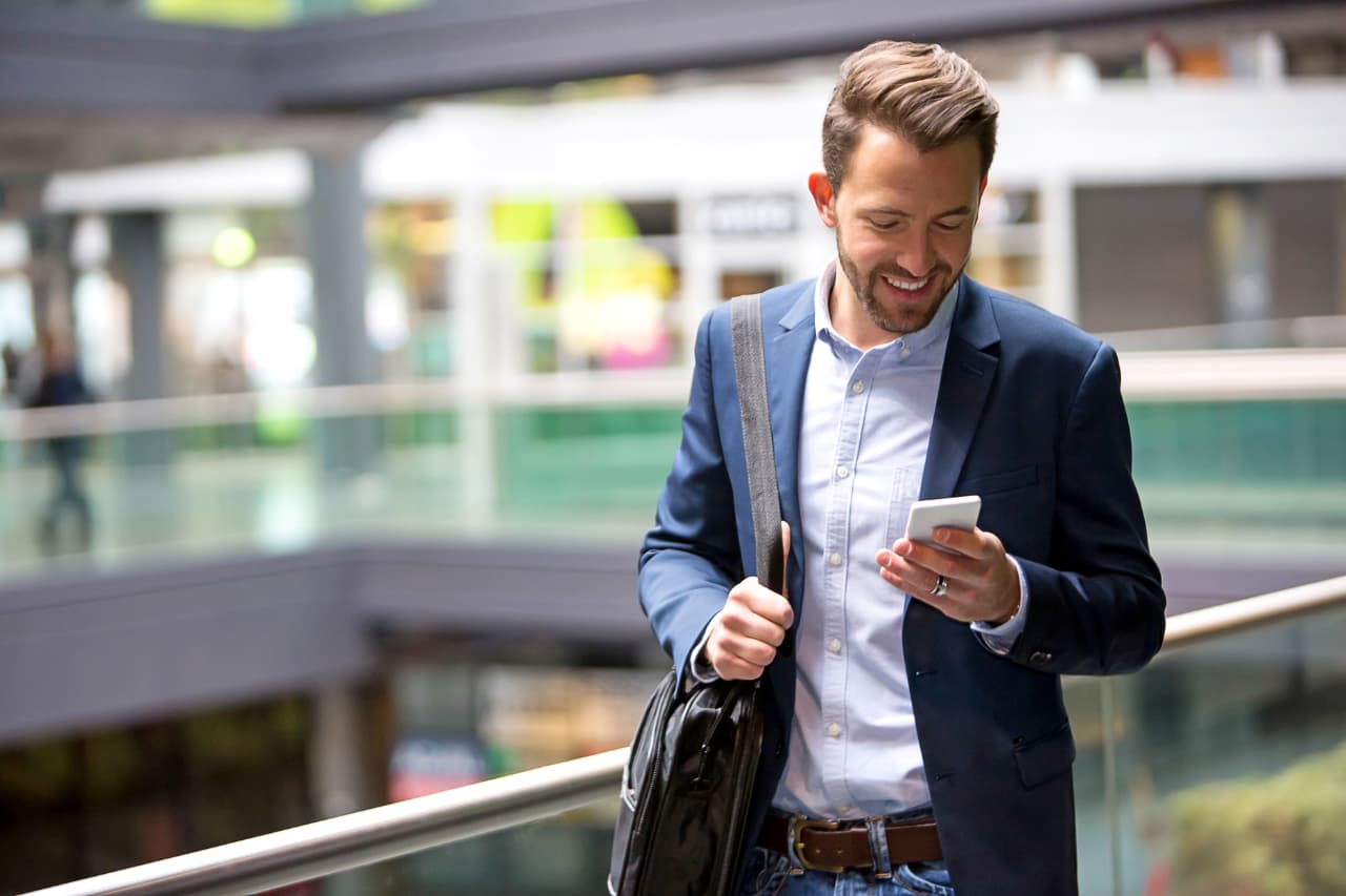 homem usando smartphone para acessar app desenvolvido com sap hybris commerce